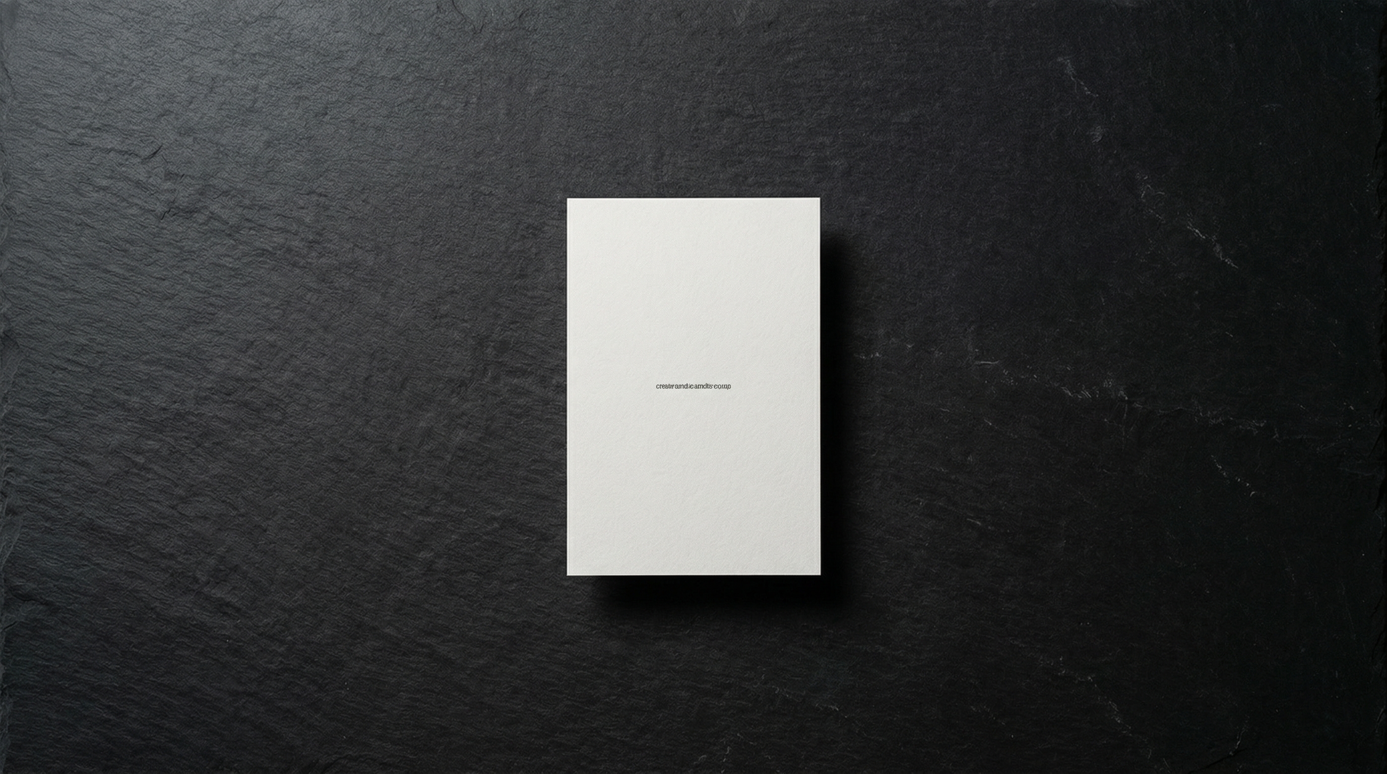 Single white sheet of paper on dark slate surface with generous empty space around it